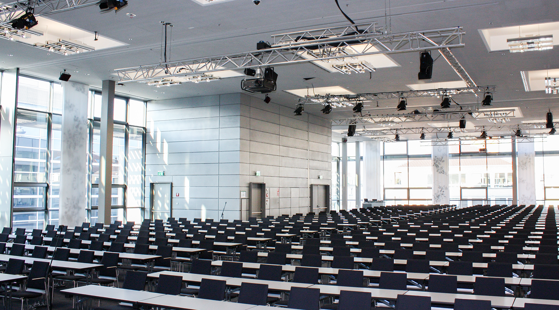 Ein moderner Konferenzsaal mit vielen Fenstern und Stühlen mit Tischen