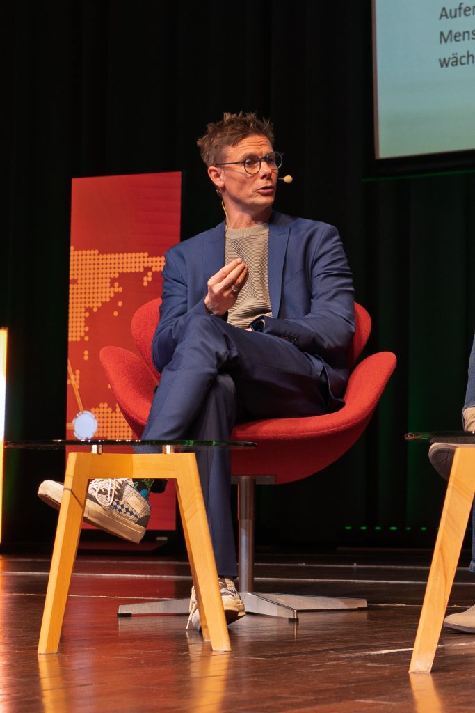 Ein Mann sitzt auf der Bühne