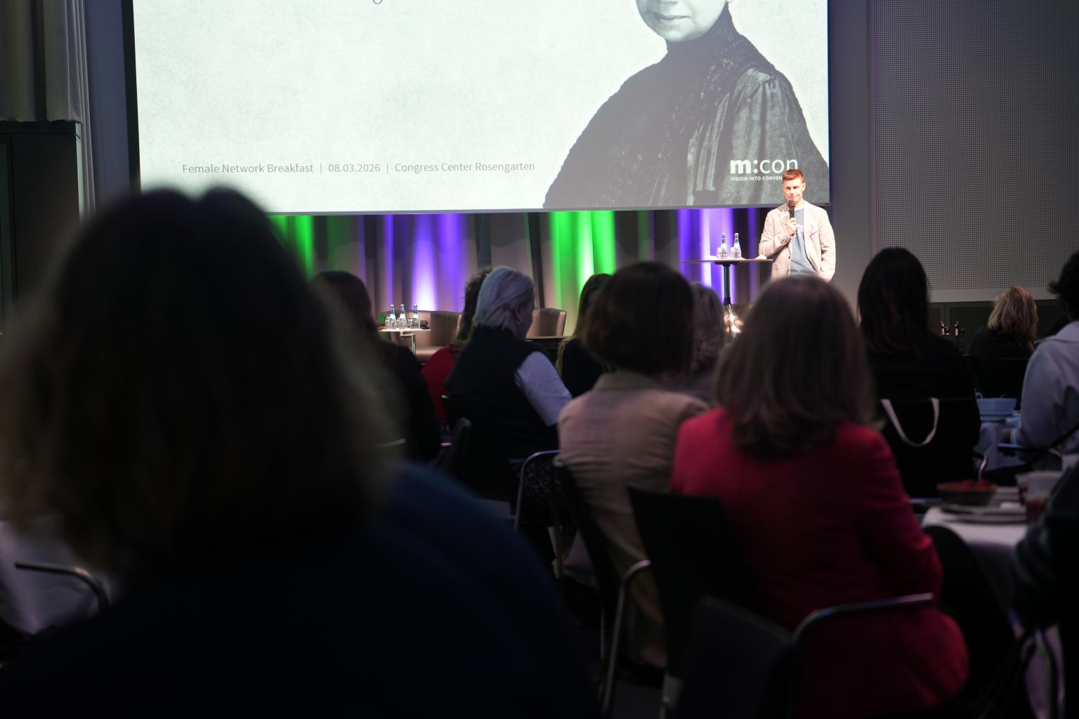 Mann auf der Bühne hält vortag