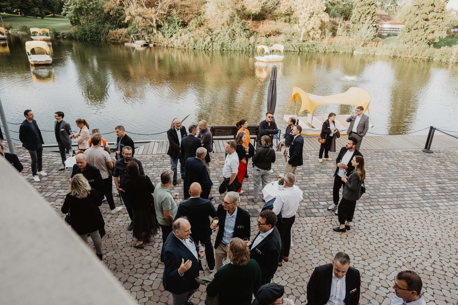 Gruppe von Personen bei einem Empfang draußen am Wasser